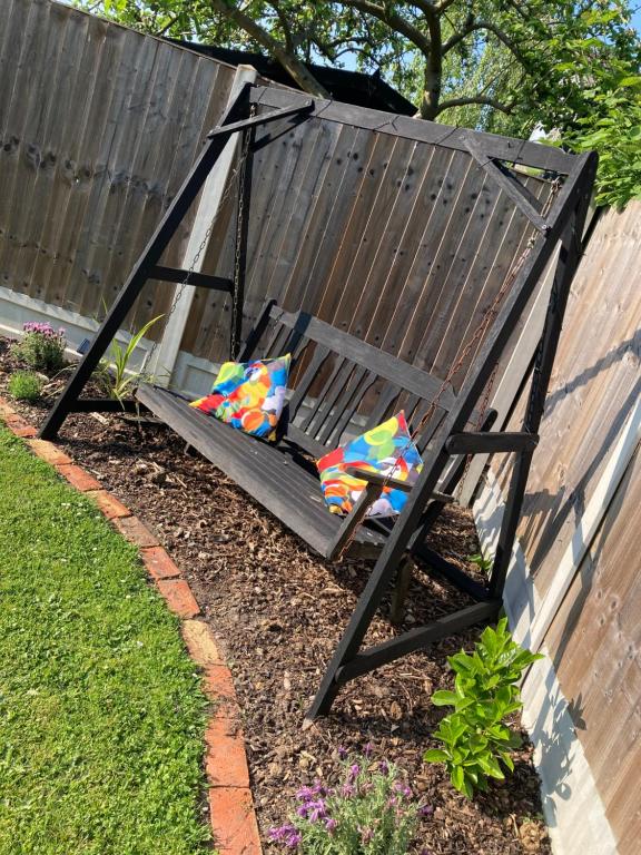 a swing with pillows sitting in a yard at Lime Tree Cottage in Tillingham