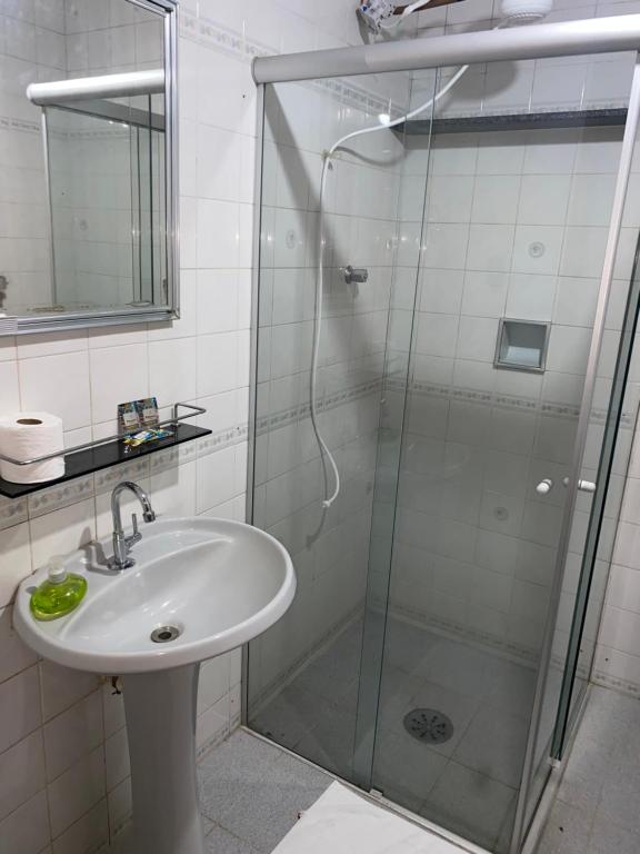 a bathroom with a sink and a shower at Casa de hóspedes in Itapira