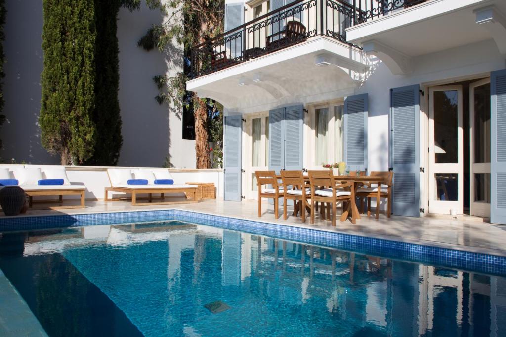 a swimming pool with a table and chairs next to a house at Anassa in Polis Chrysochous