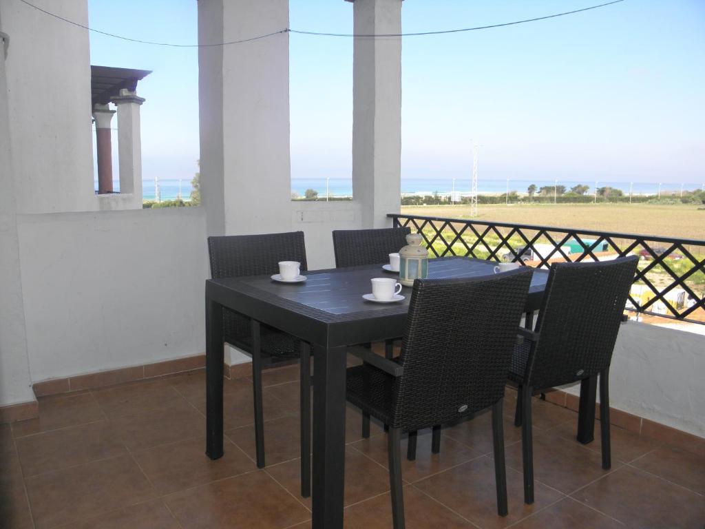 una mesa negra y sillas con vistas al océano en Apartamento Sol & Orilla, en Zahara de los Atunes