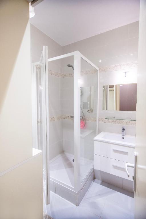 une salle de bain blanche avec une douche et un lavabo dans l'établissement Centre-ville, proche port, à La Ciotat