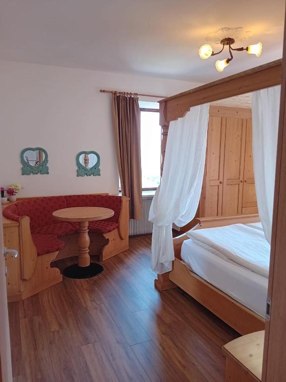 a bedroom with a canopy bed and a table at la fonte in Sporminore
