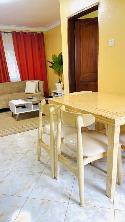 a living room with a wooden table and a couch at Spacious City Home in Kampala