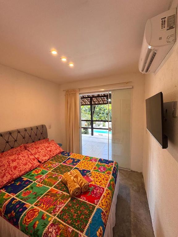 a bedroom with a bed with a colorful blanket at Suíte 8 - Village Capixaba in Gravatá