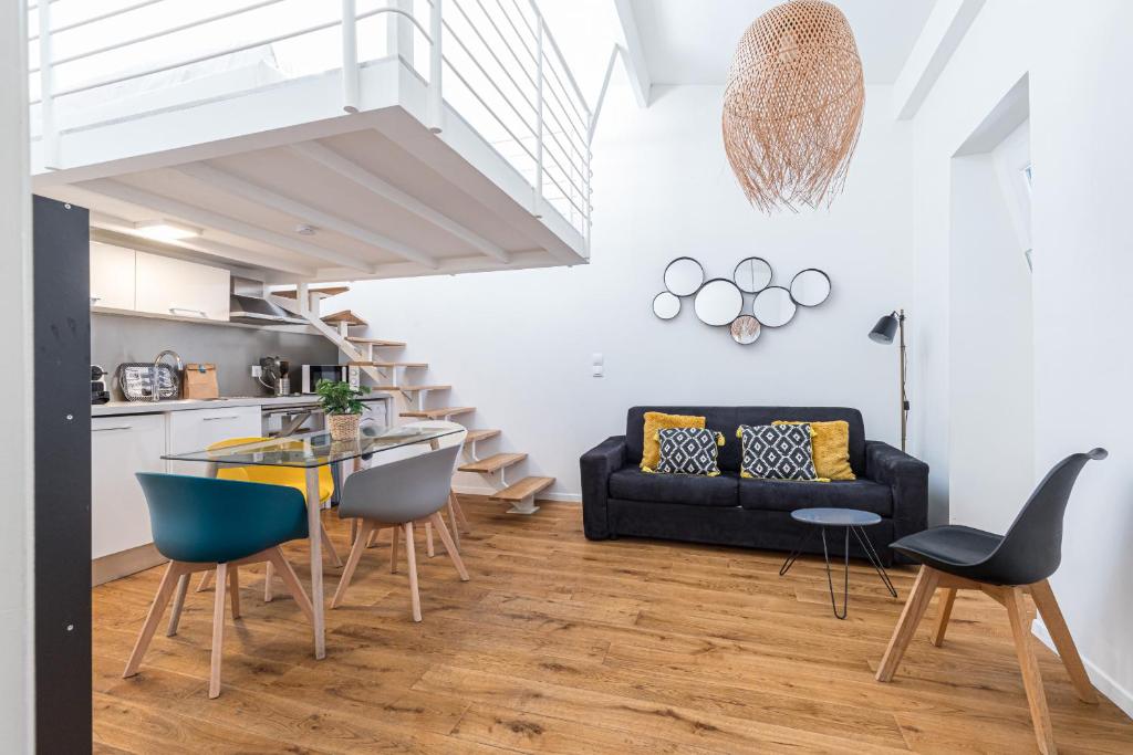 - un salon avec un canapé noir et une table en verre dans l'établissement 33 GAMBETTA - Appartement 2 pieces Mezzanine, à Nice