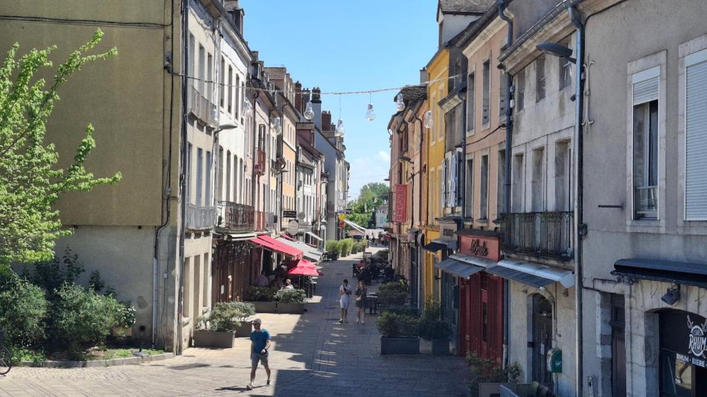 an alley with people walking down a street with buildings at Le Soleil-Levant centre-ville in Chalon-sur-Saône