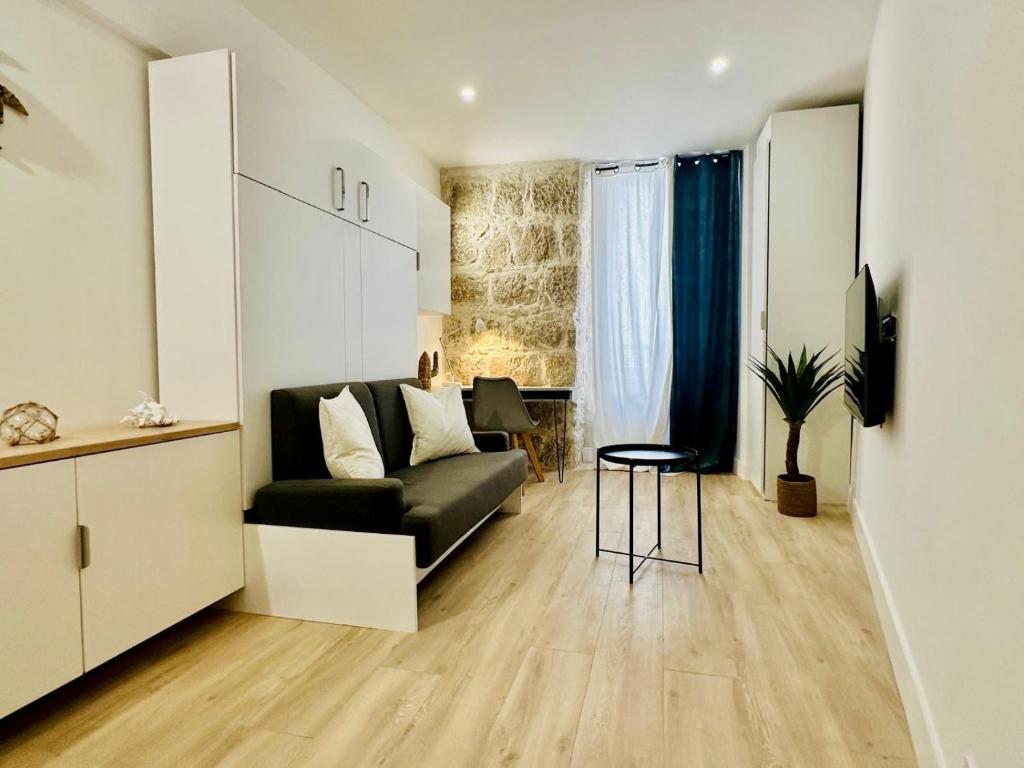 un salon avec un canapé noir et une table dans l'établissement AA G Cocon Lamartine - City center, à Nice