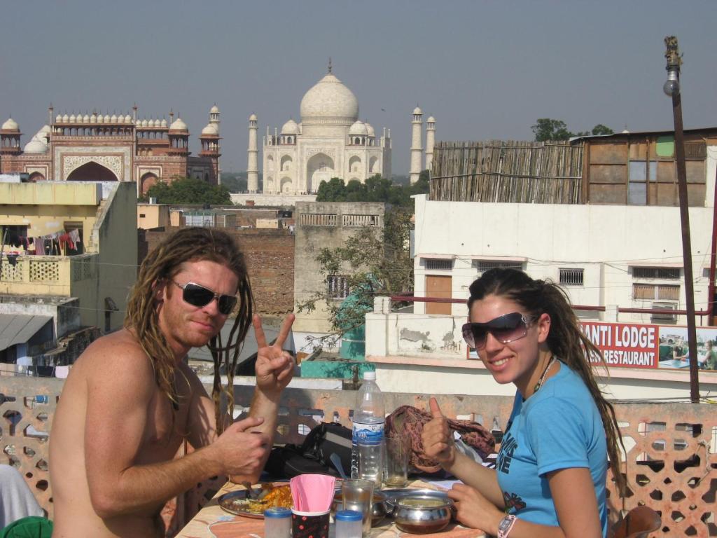 阿格拉的住宿－Hotel Sai Palace Walking Distance From Taj Mahal--View of Taj Mahal，坐在餐桌旁吃饭的男人和女人