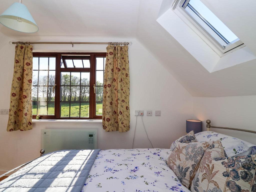 Un dormitorio con una cama y una ventana en Kernyk, en Camelford