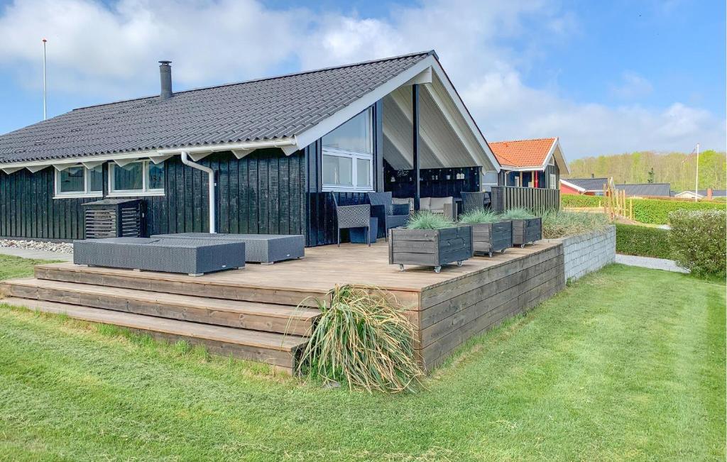 a house with a wooden deck in the yard at Gorgeous Home In Sjølund With Sauna in Sjølund