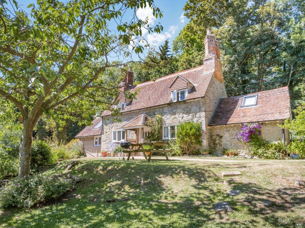 an old stone house with a picnic table in front of it at Lisle Combe Cottage in Ventnor