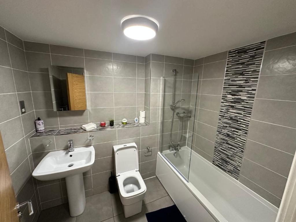 a bathroom with a sink and a toilet and a bath tub at 2 Beds Mint drive With Secure car Or Van Park w WiFi-Netflix No Deposit Required in Birmingham