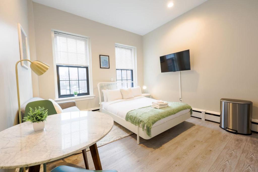 een slaapkamer met een bed, een tafel en een tv bij Bright Modern Studio in the South End in Boston