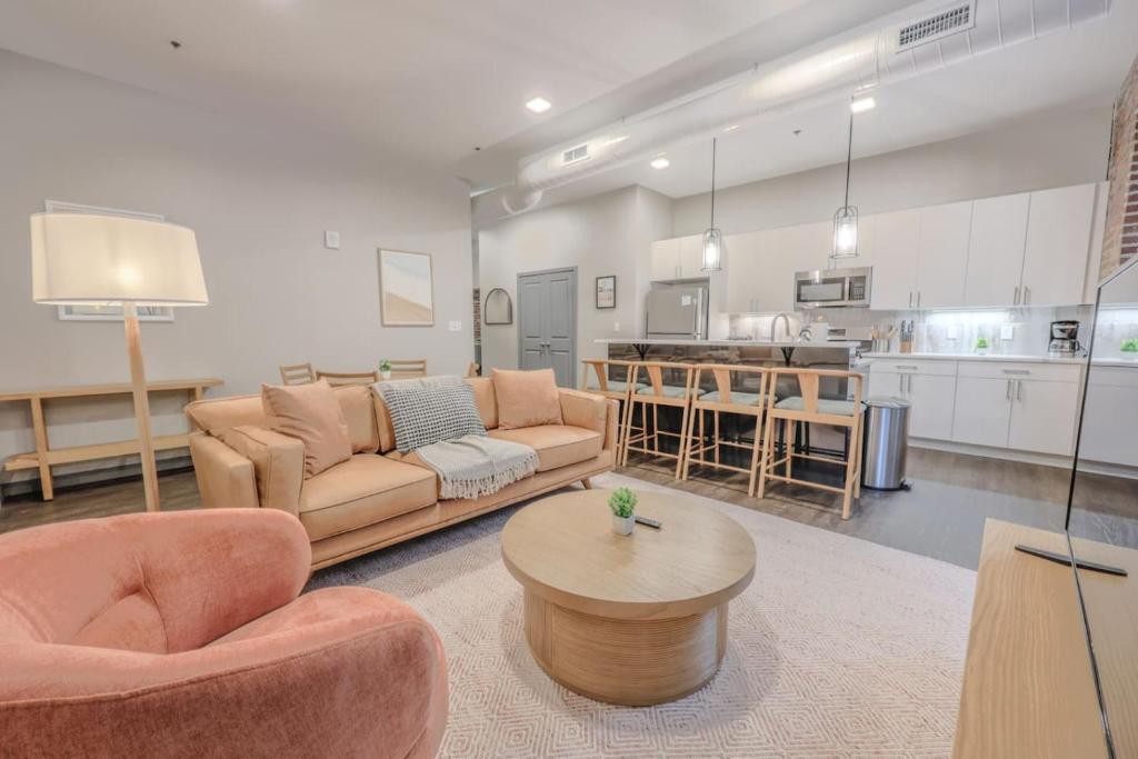 a living room with couches and a table and a kitchen at Elegant 2 Bedroom Prime Location in Boston