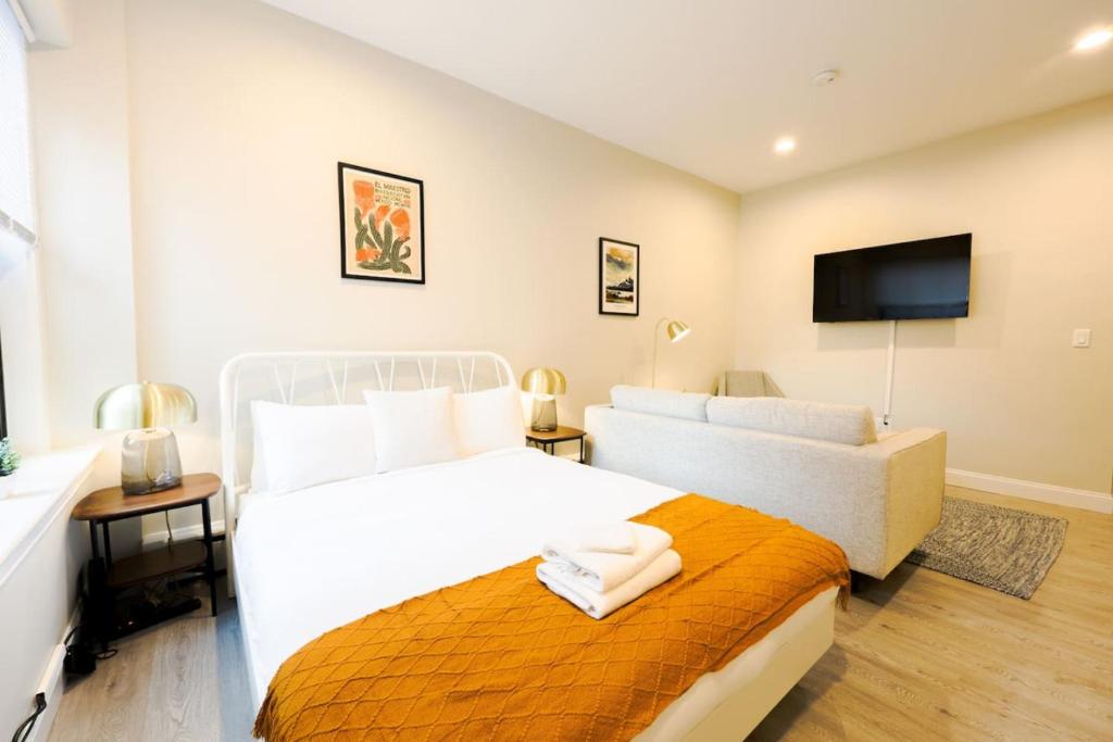 a bedroom with two beds and a flat screen tv at Bold and Spacious Studio Back Bay in Boston