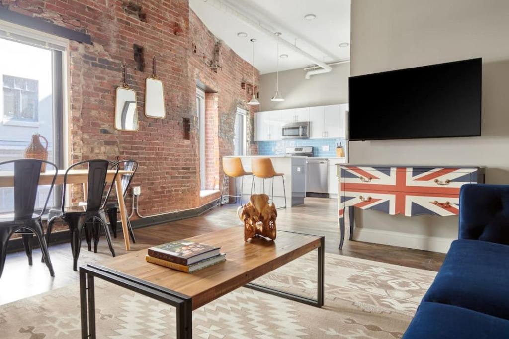 een woonkamer met een bakstenen muur en een tafel bij Spacious 4bed Loft Downtown Boston Beacon Hill in Boston