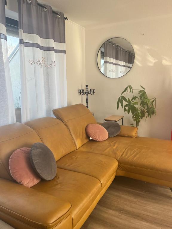a brown leather couch in a living room with a mirror at Faber Penthouse in Bad Oeynhausen