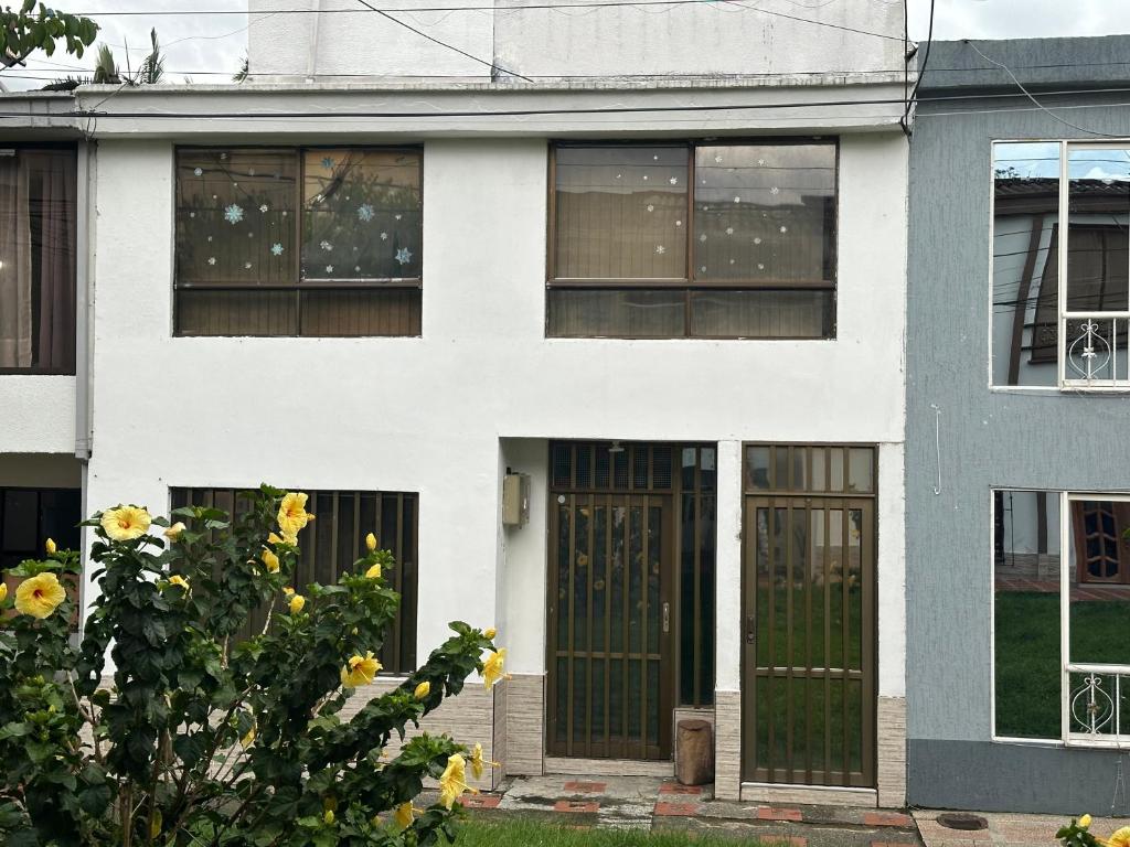 a white house with front doors and windows at Alojamientos por aeropuerto villa olímpica estadio expofuturo in Pereira