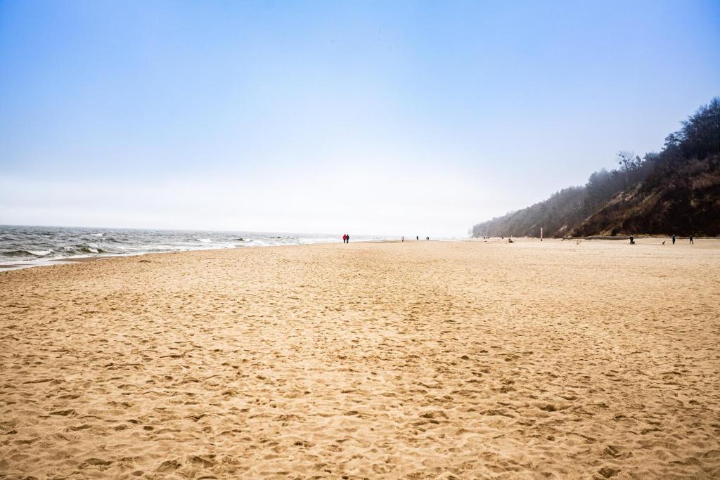 a beach with people walking on the sand at Ostrowo LATEM in Ostrowo