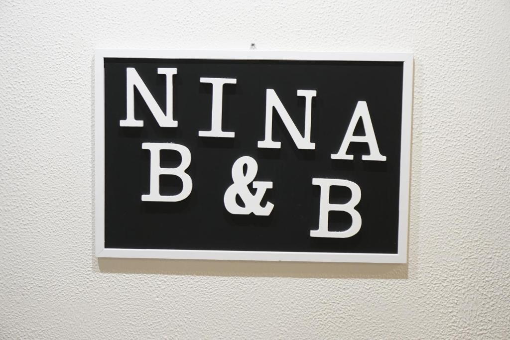 a black and white sign on a wall at Nina B&B in Rho
