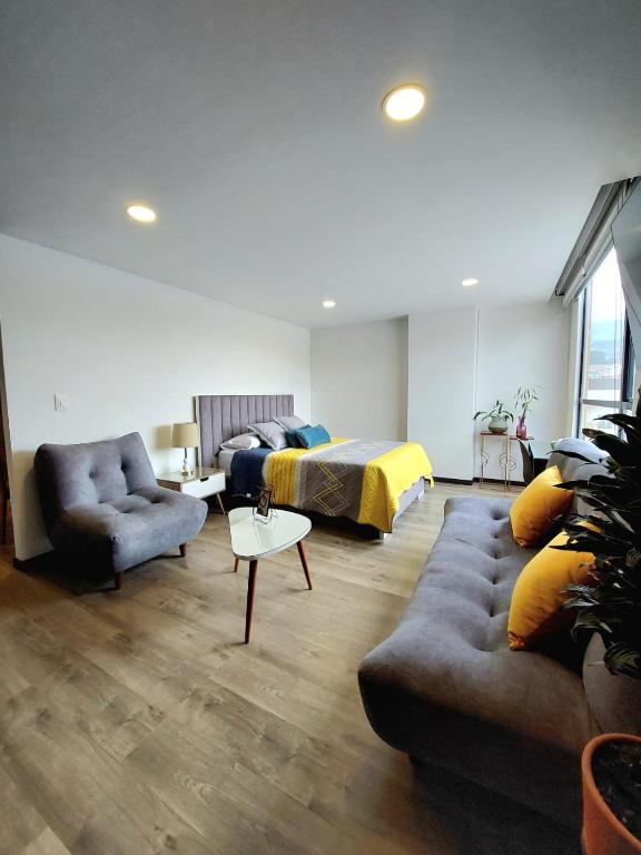 a living room with a bed and a couch and a table at Acogedor y central Apartamento ! in Pasto