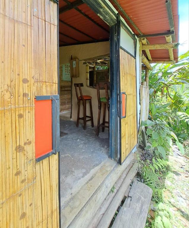 an open door of a wooden house with a table and chairs at Casa Azúl, Refugio Natural Jacaranda in Cocorná