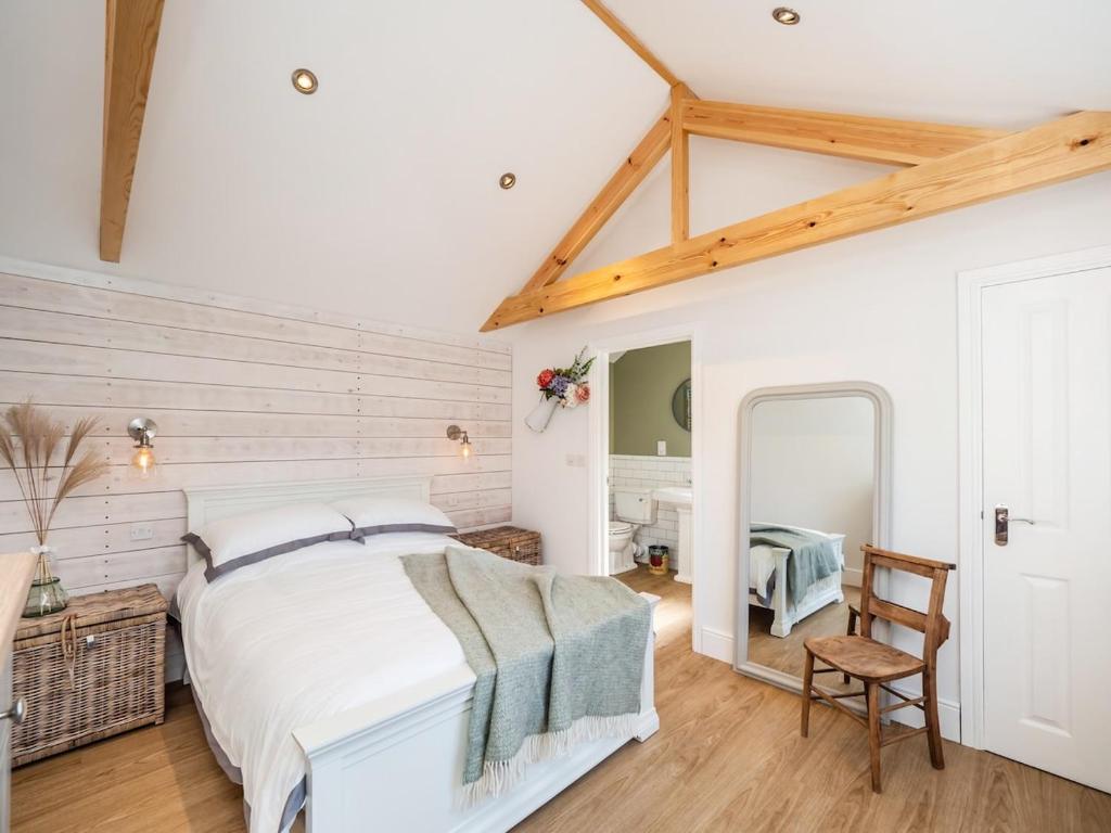 een slaapkamer met een bed, een tafel en een stoel bij Garden Cottage, Cosy, Private, Short drive to beach in North Walsham