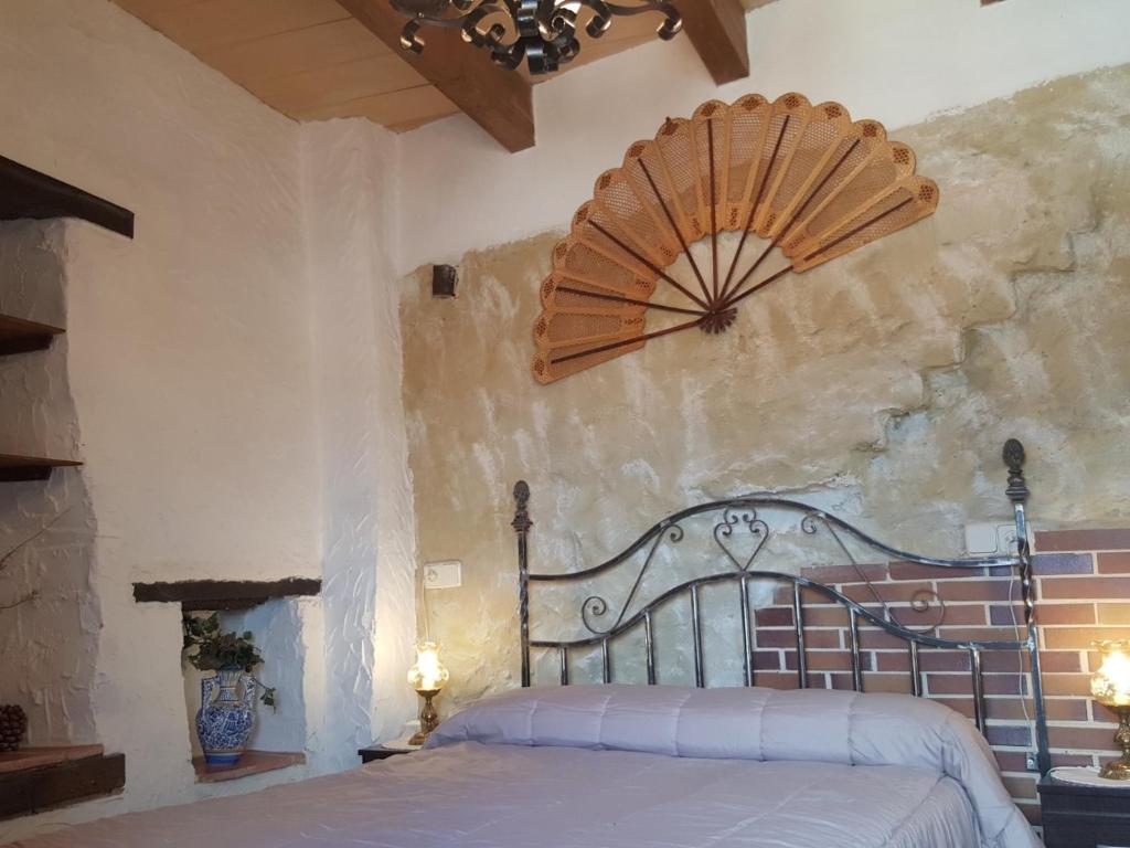 Mirador de Cerrato في بالينثيا: غرفة نوم بسرير ومروحة على الحائط