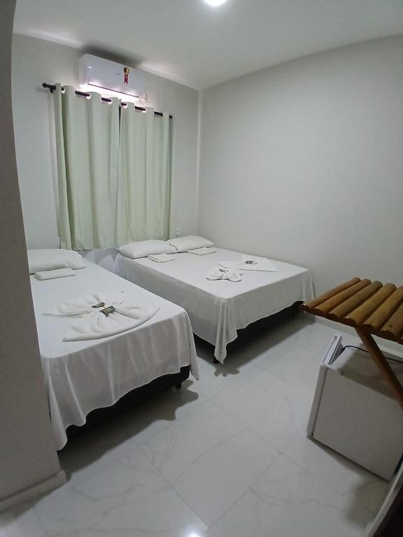 a room with two beds and a window at Pousada Brilho dos Lençóis in Barreirinhas