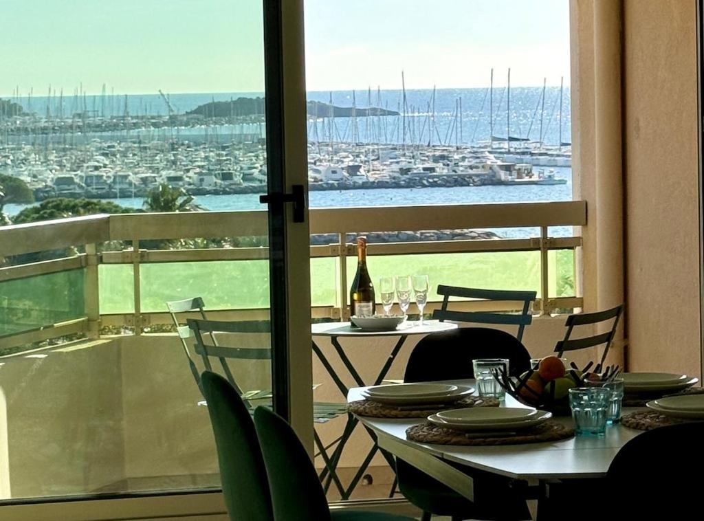 d'une table et de chaises sur un balcon avec vue sur le port. dans l'établissement Beautiful apartment stunning view of the Lion de Mer, à Saint-Raphaël