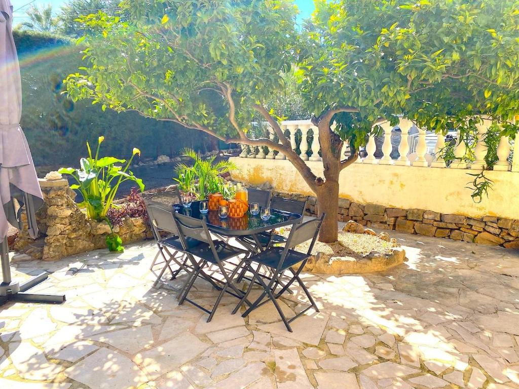 une table et des chaises sur une terrasse avec un arbre dans l'établissement Villa Oscar, au Cannet