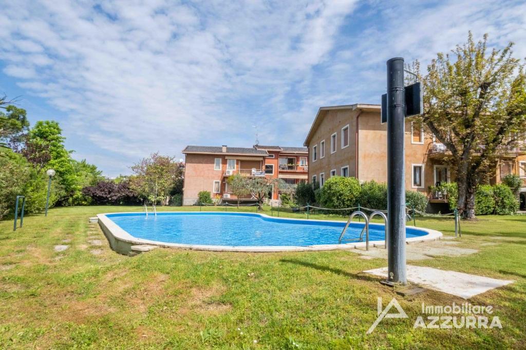 a swimming pool in a yard in front of a house at Darina - Immobiliare Azzurra in Lazise
