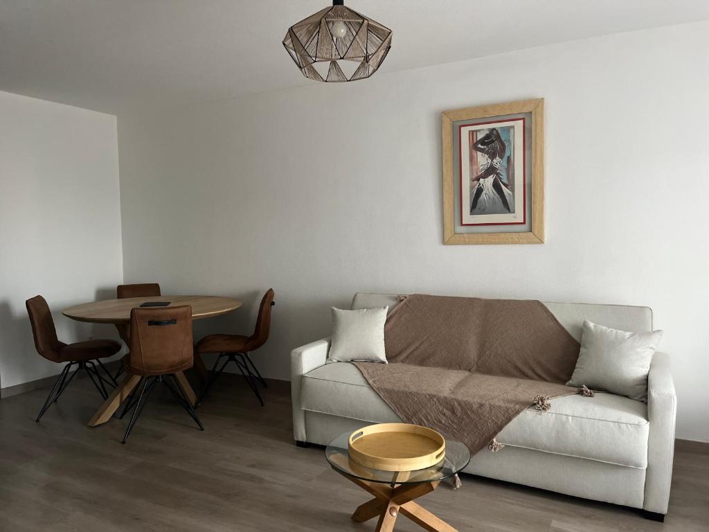 un salon avec un canapé et une table dans l'établissement Appartement plus place de parking en sous sol privatif, à Ajaccio