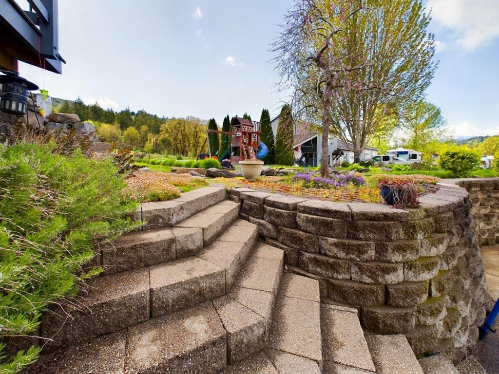 a stone retaining wall with stairs in a garden at 2 spaces More Space with 2 units at same location PNW Retreat in Philomath