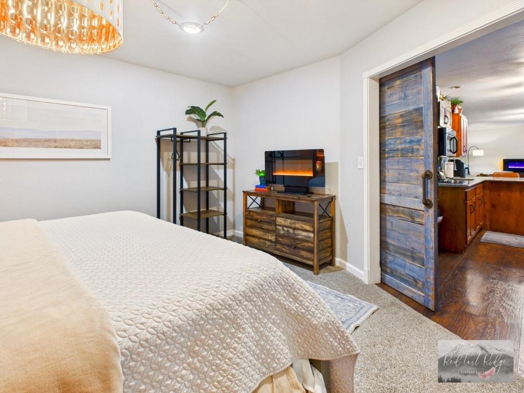 a bedroom with a bed and a tv and a door at 2 spaces More Space with 2 units at same location PNW Retreat in Philomath