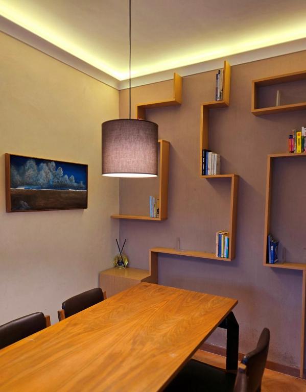 a dining room with a wooden table and shelves at Giopi Home in Vitinia
