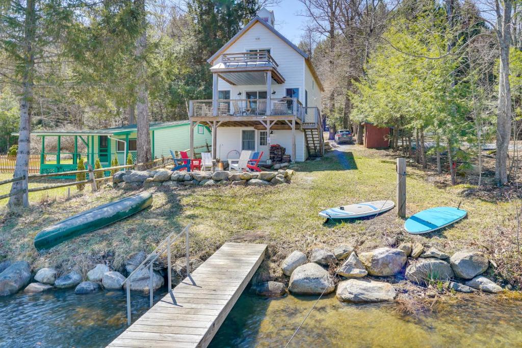 a house with a dock and boats in the water at Paddle, Swim and Hike Family Lake House in Vermont in Wallingford