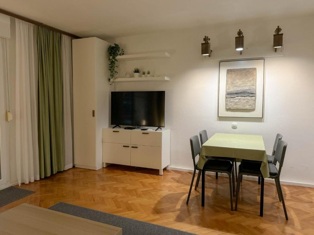 a dining room with a table and a television at Apartment Romeo in Crikvenica