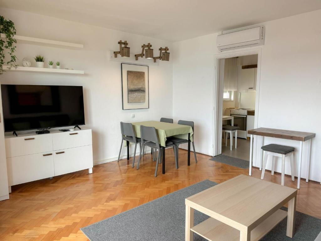 a living room with a table and a tv at Apartment Romeo in Crikvenica