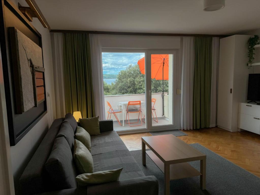 a living room with a couch and a large window at Apartment Romeo in Crikvenica
