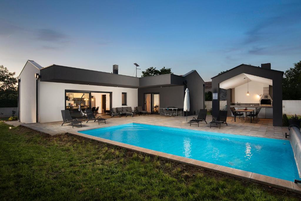 a house with a swimming pool in the yard at Vila Nora with heated pool in Marčana
