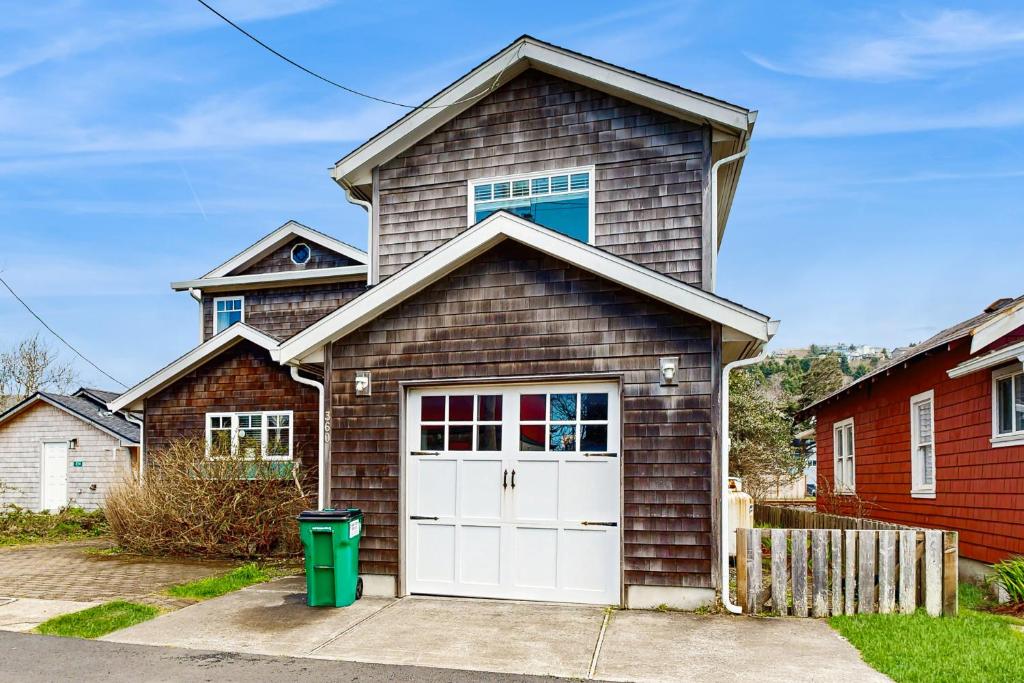 a brown house with a white garage door at Tufted Puffin in Rockaway Beach