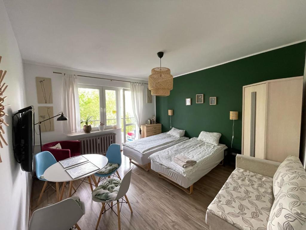 a living room with a bed and a table at Pokoje Ostróda Centrum in Ostróda