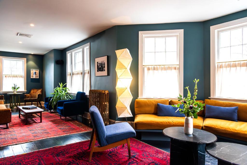 Una sala de estar con sofás, mesas y ventanas. en Hotel Kinsley, en Kingston