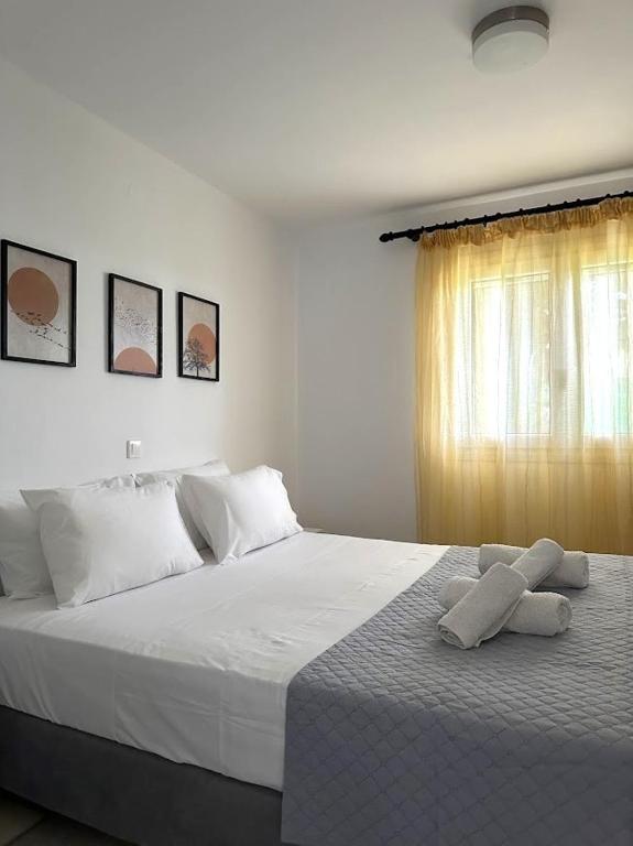 a bedroom with a white bed with towels on it at Barewake 's place Charming Retreat - Calm escape Apt in Kamári