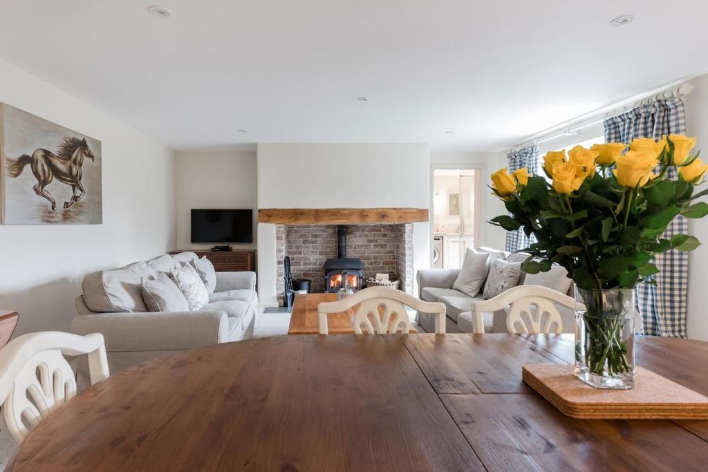 ein Wohnzimmer mit einem Holztisch und gelben Blumen in der Unterkunft A Charming Cottage, Christow Dartmoor National Park in Christow