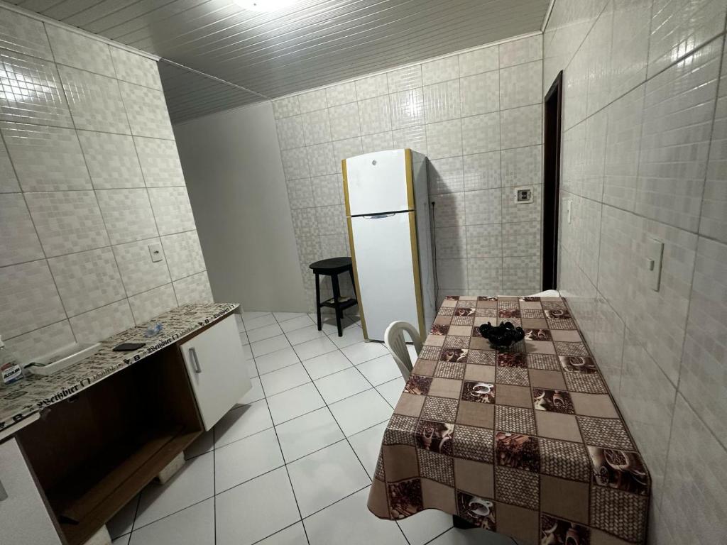 a kitchen with a table and a refrigerator in it at Apartamento em Jequié para São João in Jequié