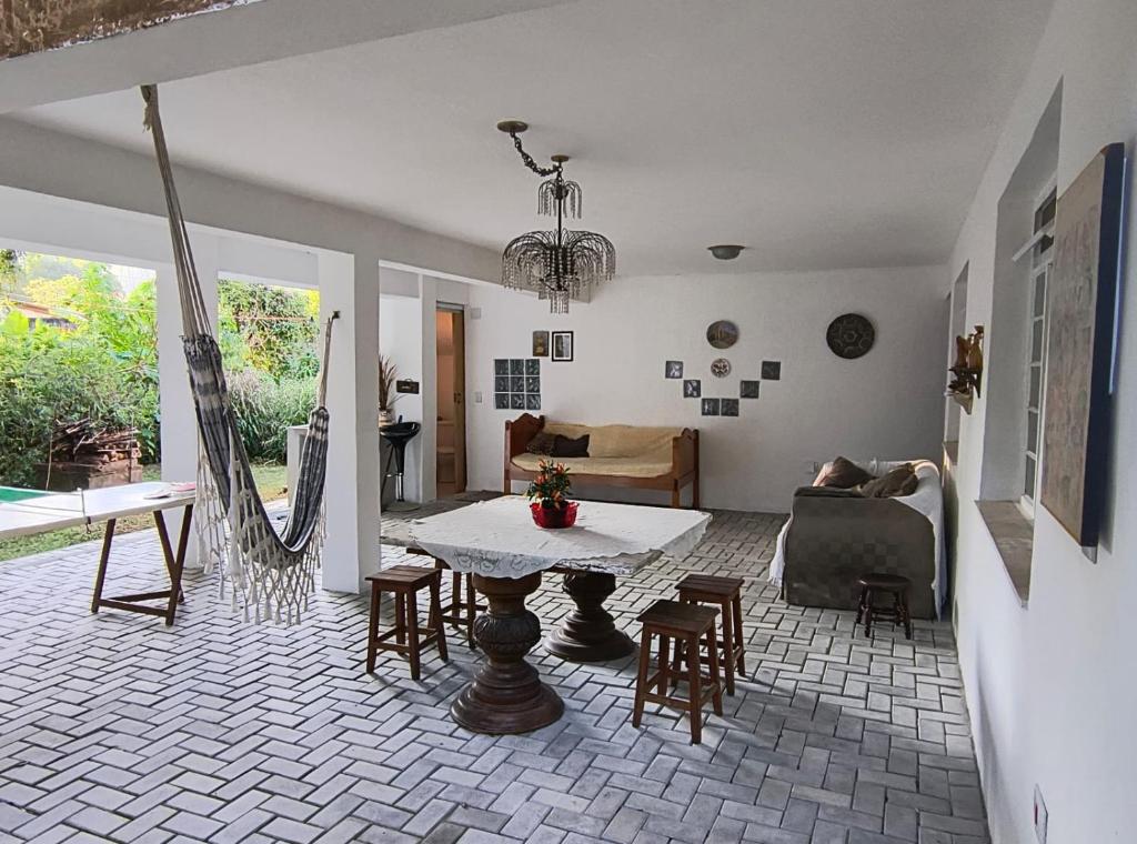 a living room with a table and chairs at Pousada Casa Cristal Mineiro in Santo Antônio do Pinhal