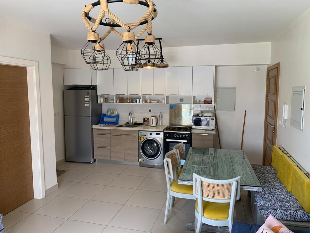 a kitchen with a table and chairs and a kitchen with a microwave at Chalet in the marassi marina 2 in El Alamein
