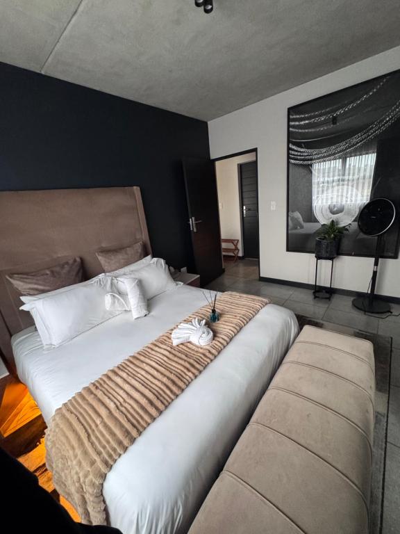 una camera da letto con un grande letto bianco con due cuscini di Cityescapes 2F in Waterfall Midrand - Beautiful self catering 2 bedroom unit next to Kyalami Racetrack with free WiFi swimming pool gym and restaurant - Perfect for a small family a Midrand